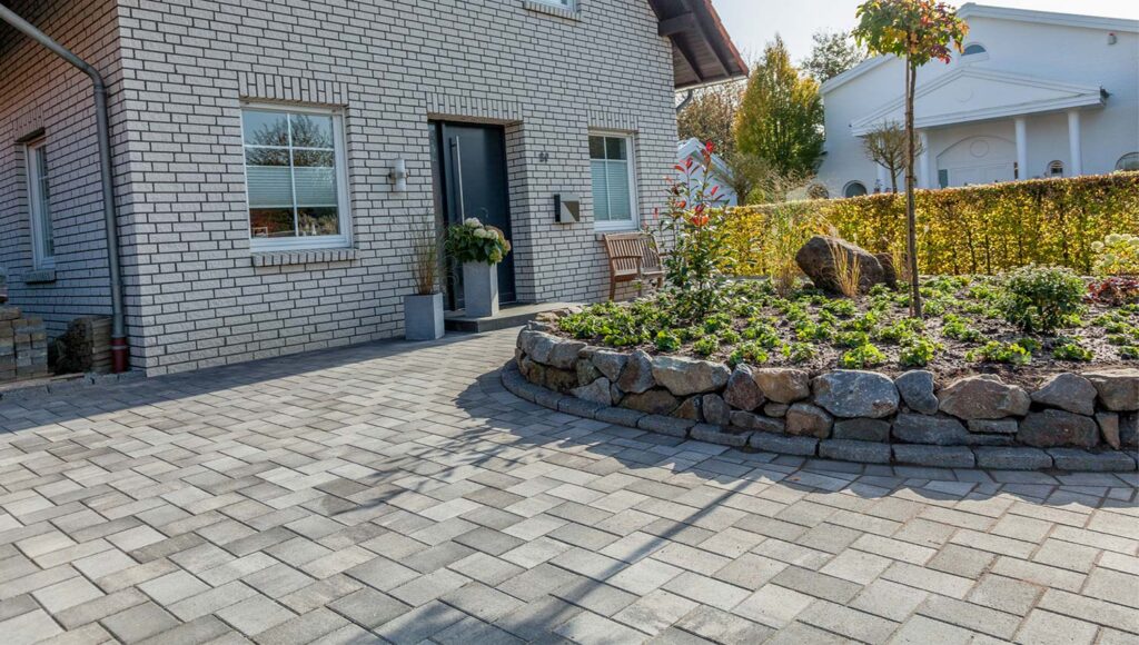 Wasserdurchlässige Pflastersteine vor einem Haus 